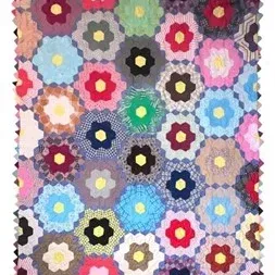 Handmade vintage Grandmother's Flower Garden patchwork quilt featuring colorful hexagonal fabric pieces.