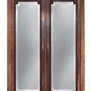 Antique carved wooden armoire featuring two full-length mirrored doors, a bottom drawer, and an ornate pediment crown.
