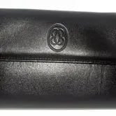 Black leather flap wallet featuring an embossed oval monogram logo on the front.