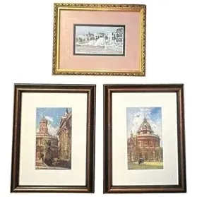 Set of three framed architectural prints, including a pair depicting European landmarks in matching dark wood frames and a landscape...