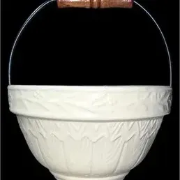 Vintage off-white ceramic mixing bowl featuring embossed floral detail and a wire bail handle with a turned wooden grip.