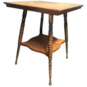 Antique wooden side table featuring spool-turned spindle legs and a contoured lower display shelf, showing signs of vintage wear and...