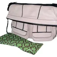 Off-white leather diaper bag shoulder tote with dark trim, front flap pockets, and a matching green patterned changing pad.