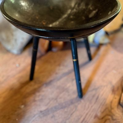 Mid-century modern black wooden tripod pedestal bowl with gold accent rings on tapered legs.