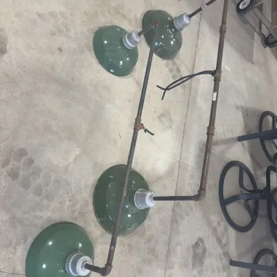 Sale Photo Thumbnail #69: Set of four industrial green porcelain enamel barn light fixtures attached to pipe conduit framing, displaying vintage wear and surface patina.