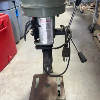 Sale Photo Thumbnail #169: Central Machinery benchtop drill press featuring a speed chart plate, adjustable table, and three-spoke feed handle.