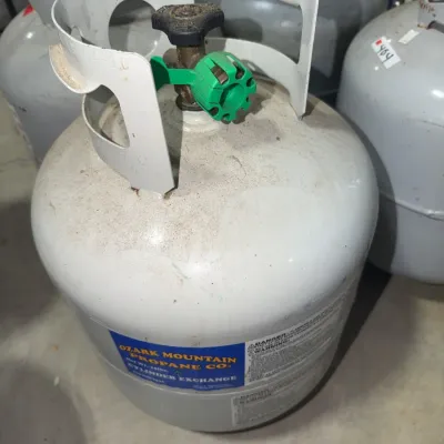 Sale Photo Thumbnail #178: White 20 lb Ozark Mountain Propane Co. cylinder with valve safety cap.