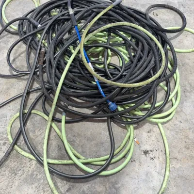 Sale Photo Thumbnail #91: Large pile of coiled heavy-duty rubber air and water hoses in various colors and lengths, showing signs of use.