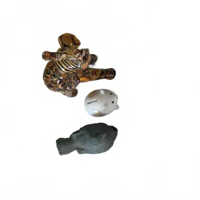Sale Photo Thumbnail #295: Trio of small animal figurines, including a decoupaged elephant, a ceramic piggy bank, and a textured bird sculpture, shown from an overhead perspective.