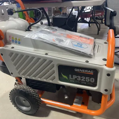 Sale Photo Thumbnail #119: Generac LP3250 portable propane-powered generator, featuring a wheeled orange and gray frame and original manual.