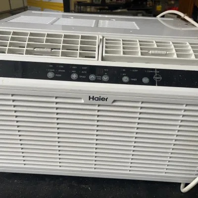 Sale Photo Thumbnail #162: Haier white window air conditioner unit featuring a digital control panel, top vents, and power cord.