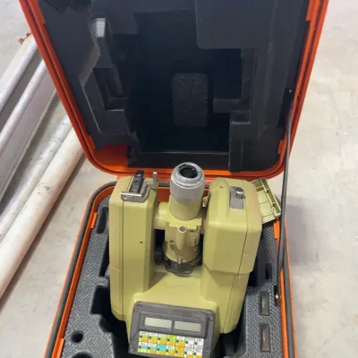 Sale Photo Thumbnail #44: Vintage Topcon electronic total station surveying instrument housed inside its original bright orange hard transport case.