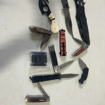 Sale Photo Thumbnail #151: Collection of modern tactical and pocket knives, including a butterfly knife, skinning knife with gut hook, and a Winchester folding knife.
