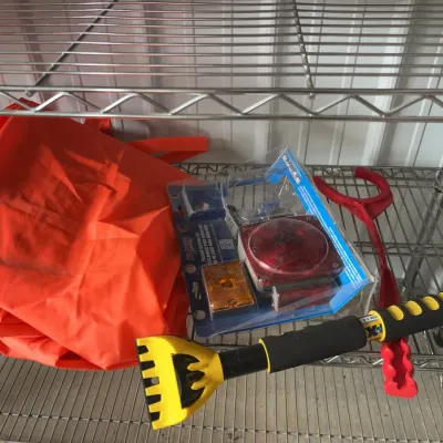 Sale Photo Thumbnail #22: Blazer trailer lighting kit in original clamshell packaging displayed with a bright orange bag, yellow ice scraper, and red plastic tongs on wire shelving.