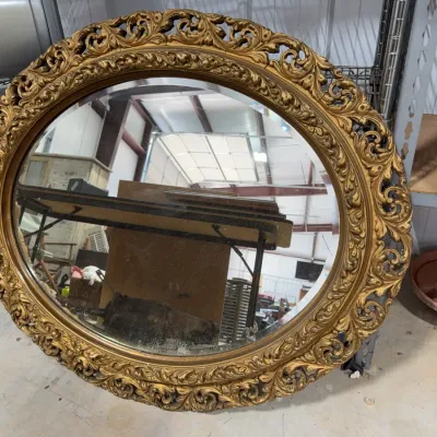 Sale Photo Thumbnail #12: Large vintage ornate round wall mirror with an elaborate gilded foliage frame.