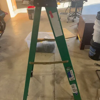 Sale Photo Thumbnail #72: Green Werner fiberglass 4-foot stepladder with a 225 lb load capacity rating, showing minor wear.