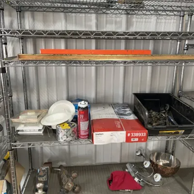 Sale Photo Thumbnail #31: Wire shelving unit organized with assorted hardware, a Pfister faucet box, spray adhesive, trailer hitches, and various household fixtures.