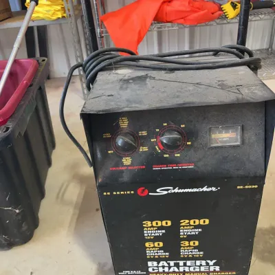 Sale Photo Thumbnail #35: Schumacher SE-6030 heavy-duty battery charger and engine starter on a wheeled cart, showing signs of cosmetic wear.