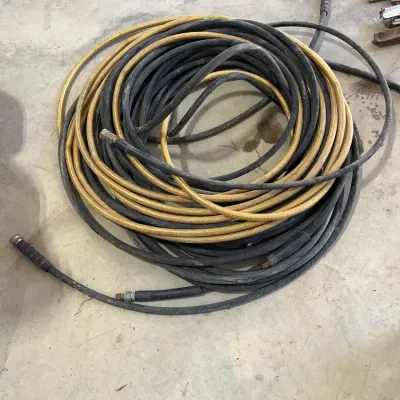 Sale Photo Thumbnail #41: Coiled industrial pressure washer or air hoses with brass fittings, showing typical wear from garage or shop use.