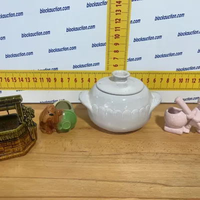 Sale Photo Thumbnail #123: Collection of vintage ceramic figurines and tabletop items, including a wishing well Planter, dog boot novelty holder, covered white casserole dish, and a pink baseball boy figure.