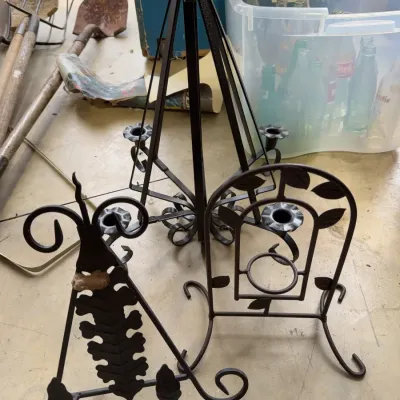 Sale Photo Thumbnail #236: Collection of black wrought iron candle holders and plant stands featuring scrolls, leaves, and various sizes.