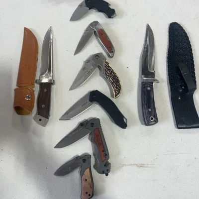 Sale Photo Thumbnail #152: Collection of modern pocket knives and fixed-blade hunting knives with accompanying leather sheaths.