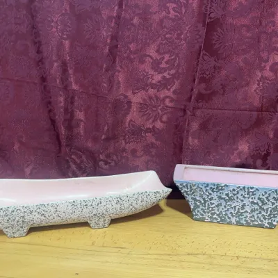 Sale Photo Thumbnail #133: Pair of mid-century ceramic planters featuring mottled gray and white exteriors with soft pink glazed interiors.