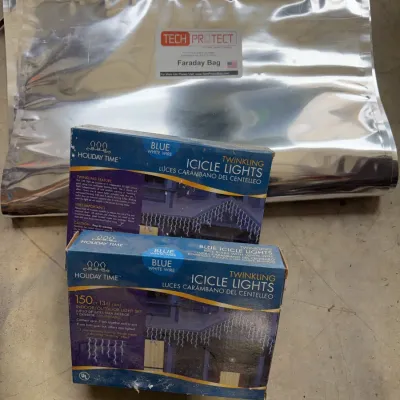 Sale Photo Thumbnail #243: Tech Protect Faraday bag paired with two boxed sets of Holiday Time blue twinkling icicle light sets.