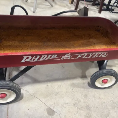 Sale Photo Thumbnail #173: Vintage classic red Radio Flyer Model #18 metal wagon showing heavy interior rust and surface wear.