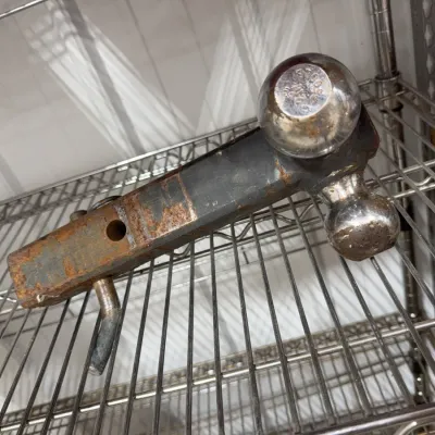 Sale Photo Thumbnail #11: Heavy-duty dual-ball trailer hitch mount with hitch pin, showing heavy rust and surface wear.
