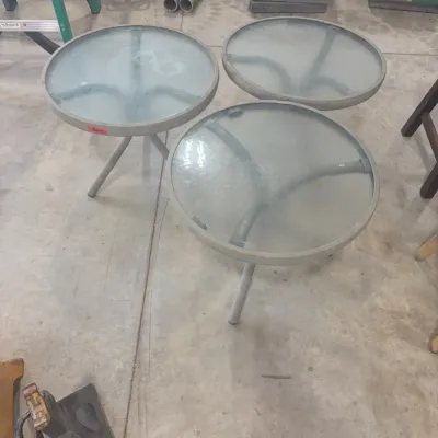 Sale Photo Thumbnail #66: Set of three matching round patio side tables featuring frosted glass tops and grey tubular metal frames.