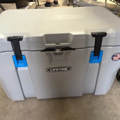 Sale Photo Thumbnail #171: Lifetime 77-quart high-performance grey ice chest cooler featuring durable T-latch closures and bottle opener attachment.