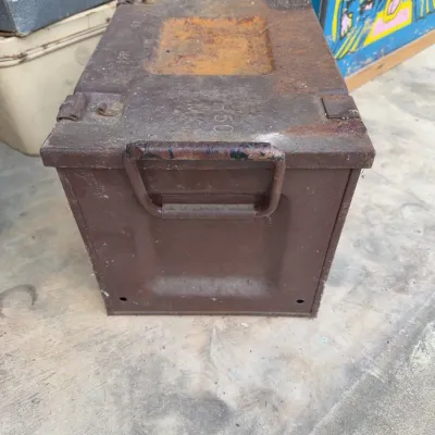 Sale Photo Thumbnail #255: Vintage heavy-duty metal military ammunition box showing heavy surface rust, wear, and stamped markings on the top lid.