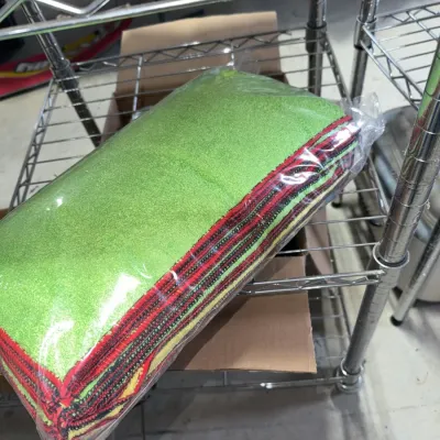 Sale Photo Thumbnail #211: Packaged set of green, red, and black microfiber cleaning cloths resting on a wire shelf.
