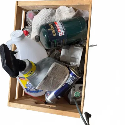 Sale Photo Thumbnail #111: Wooden crate filled with assorted garage supplies, including a Bernzomatic propane tank, cleaning sprays, and aerosol cans.