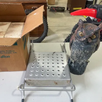 Sale Photo Thumbnail #154: Collection of workshop items, including a box of kiln shelf bricks, a perforated aluminum step, and a plastic owl garden decoy.