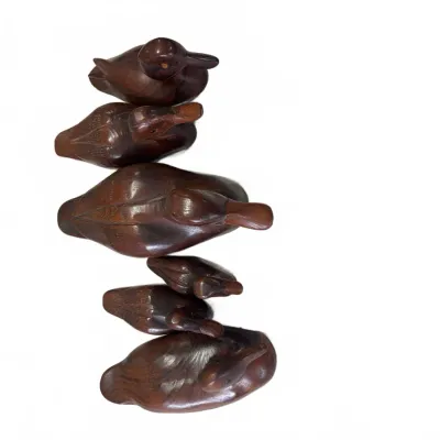 Sale Photo Thumbnail #278: Set of six hand-carved wooden duck decoys in graduating sizes, featuring smooth polished dark wood finishes.