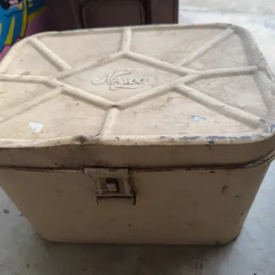 Sale Photo Thumbnail #253: Vintage Nesco metal cooler chest in beige finish with metal latch, showing age-appropriate wear.