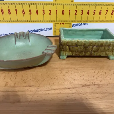Sale Photo Thumbnail #124: Two vintage green glaze ceramic art pottery pieces, including a round rest-rimmed ashtray and a small rectangular footed planter box with a textured faux-stone exterior.