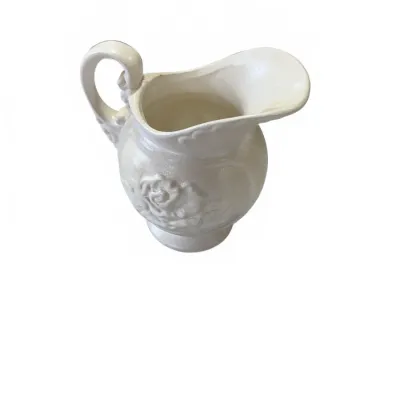 Sale Photo Thumbnail #270: Vintage white ceramic pitcher featuring an embossed rose motif and a wide spout.