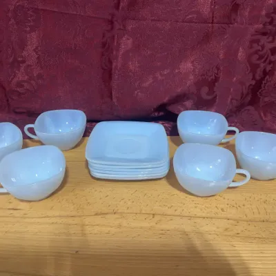 Sale Photo Thumbnail #128: Mid-century white milk glass teacup and saucer set featuring six rounded square cups and a stack of matching square saucers.