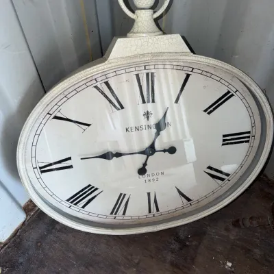Sale Photo Thumbnail #99: Large vintage-style Kensington London wall clock designed to resemble an oversized pocket watch, featuring a distressed off-white finish and Roman numerals.
