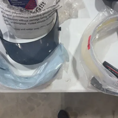 Sale Photo Thumbnail #86: Collection of Bell Racing helmet visors and accessories, including tinted and clear shields in plastic packaging alongside a dryer power cord.