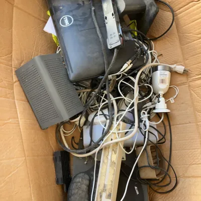 Sale Photo Thumbnail #16: Cardboard box filled with assorted electronics including a Dell monitor, power strips, security cameras, and tangled cables.