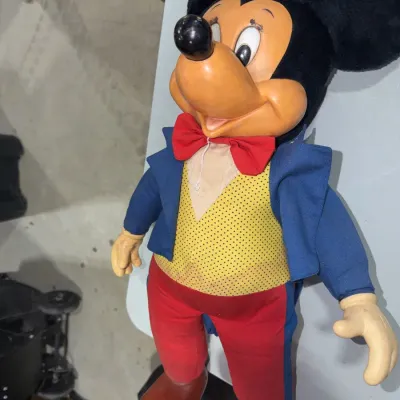 Sale Photo Thumbnail #186: Vintage Mickey Mouse doll featuring a molded vinyl face, black felt ears, and original fabric outfit with a yellow polka-dot vest and red bow tie.