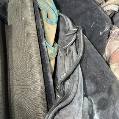 Sale Photo Thumbnail #96: Assorted canvas soft gun cases and gear bags stored in a container. Items show signs of dust, dirt, and heavy previous use.
