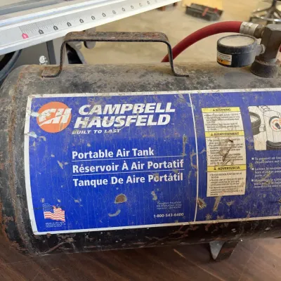 Sale Photo Thumbnail #38: Vintage Campbell Hausfeld portable air tank featuring a top carry handle, pressure gauge, and red hose attachment.
