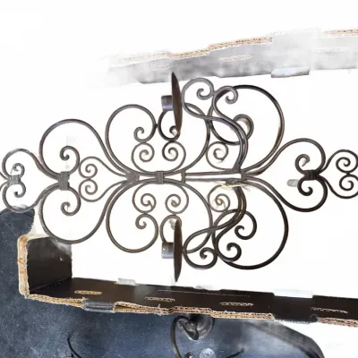 Sale Photo Thumbnail #230: Vintage dark wrought iron scrollwork wall sconce with candle holders resting inside a box.
