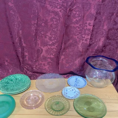 Sale Photo Thumbnail #127: Collection of assorted glassware and decorative ceramic plates, including green majolica leaf pattern plates, depression glass pieces, and a cobal-rimmed blown glass vase.