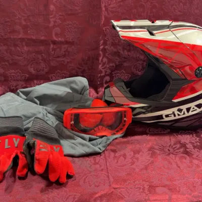 Sale Photo Thumbnail #3: GMAX motocross helmet with matching red goggles, a pair of Fly Racing gloves, and riding apparel.